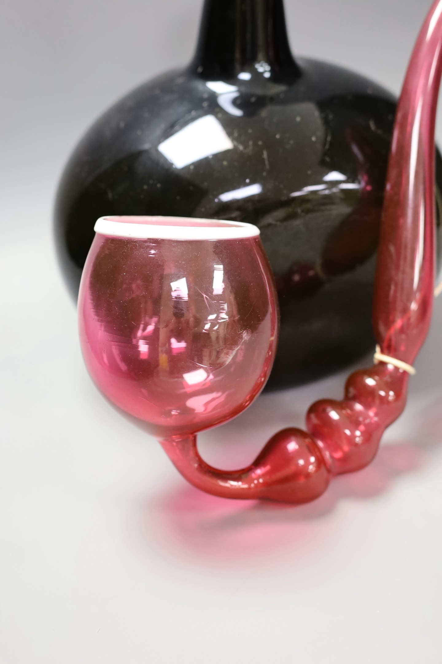 A large Georgian green glass bottle, 33 cm high and Nailsea-type ruby glass novelty pipe